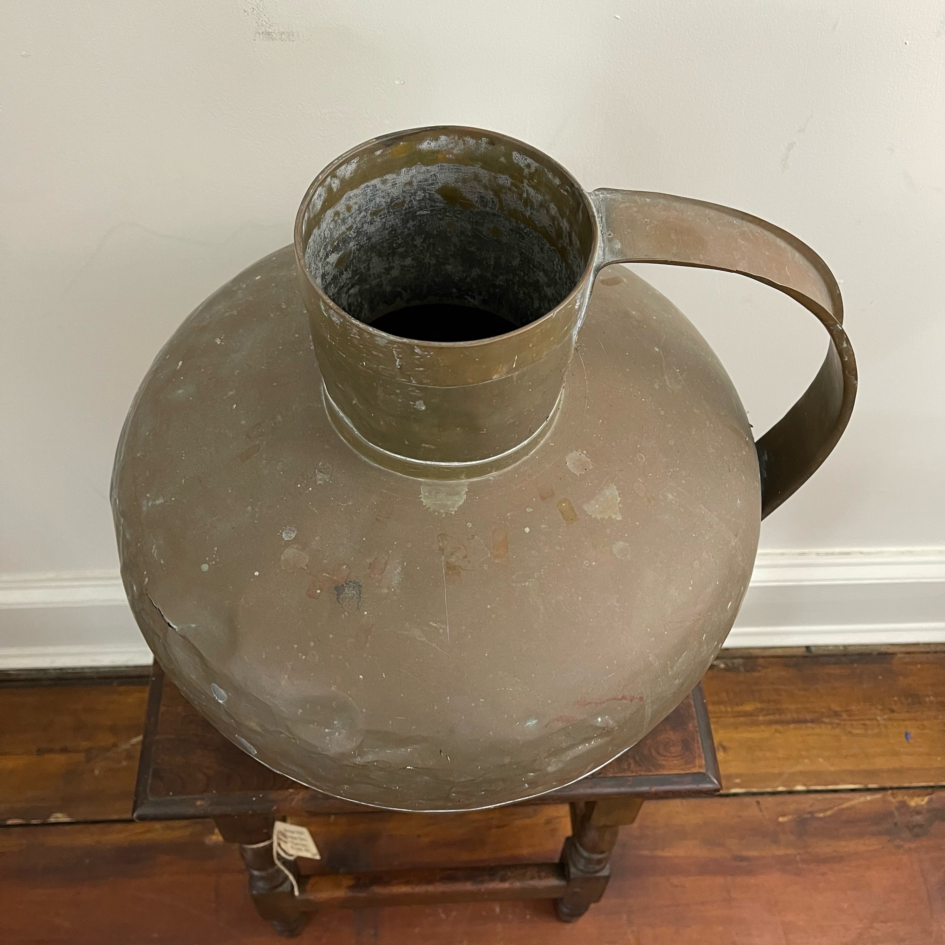 Grand pichet ancien en laiton avec réparations, vers 1900.